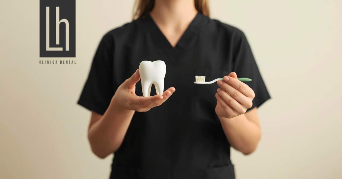 Dentista con un modelo dental y un cepillo de dientes - Cínica Dental Henríquez